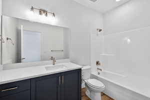 Bathroom with vanity, shower / bathtub combination, and dark wood-style flooring