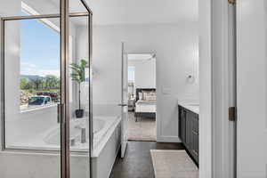 Full bathroom featuring vanity, ensuite bath, and a garden tub
