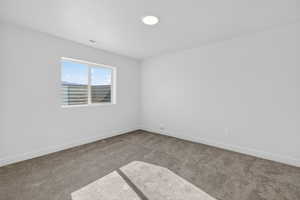 Carpeted spare room featuring baseboards