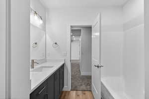 Bathroom featuring vanity, light wood finished floors, and light colored carpet