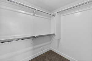 Walk in closet featuring dark carpet