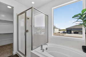Full bathroom with a garden tub, a marble finish shower, a walk in closet, and recessed lighting