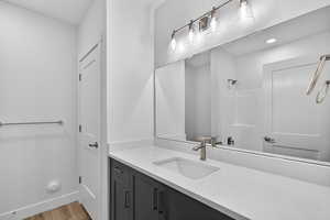Bathroom featuring vanity, a shower, and light wood-style flooring