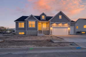 View of front of property featuring board and batten siding, driveway, covered porch, and a garage