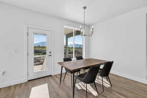 Dining area with a mountain view, light wood-type flooring, and suspended lighting