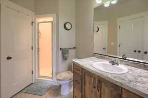 Full bath featuring vanity, a shower stall, and light tile patterned flooring