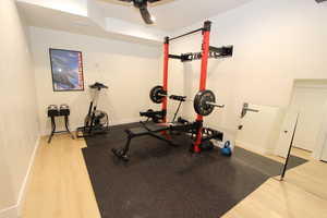 Exercise area with light wood finished floors and baseboards