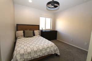 Bedroom with dark carpet and baseboards