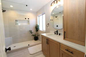 Bathroom featuring vanity, a walk in shower, and recessed lighting