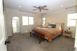 Bedroom featuring carpet floors, recessed lighting, ceiling fan, and arched walkways