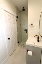 Bathroom featuring vanity, a stall shower, and light tile patterned floors