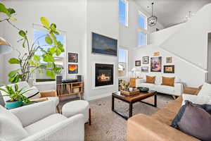 Living room with a glass covered fireplace and a high ceiling