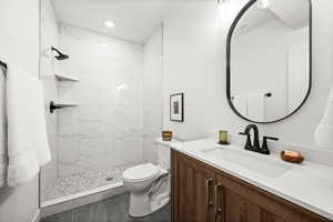 Full bath featuring vanity, a shower stall, and recessed lighting