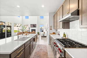 Kitchen with a glass covered fireplace, open floor plan, recessed lighting, a textured ceiling, and stainless steel appliances