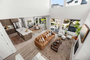 Living room with a high ceiling and light wood-type flooring