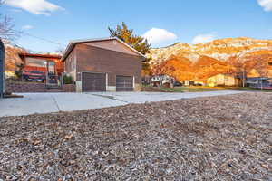View of property exterior featuring driveway, a mountain view, and an attached garage