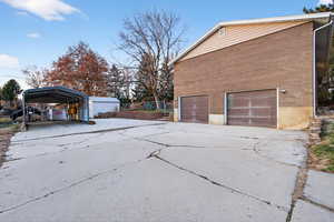 View of side of home with concrete driveway and brick siding