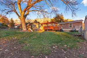 Rear view of property featuring a playground and a deck