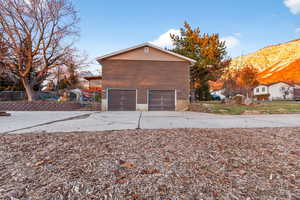 View of property exterior featuring driveway, a mountain view, and an attached garage