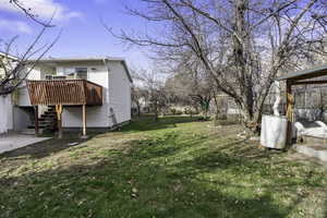 View of grassy yard with stairway and a wooden deck