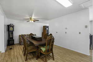 Dining room with light wood-style floors and ceiling fan