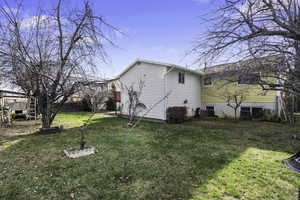 View of side of home with a lawn and a cooling unit