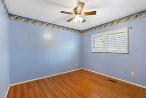 Empty room with wood finished floors and ceiling fan