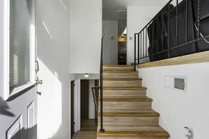 Stairs featuring wood finished floors