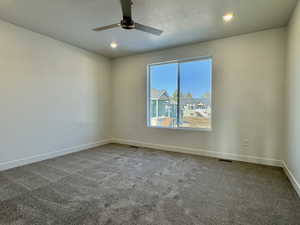 Carpeted spare room featuring recessed lighting, a textured ceiling, and ceiling fan