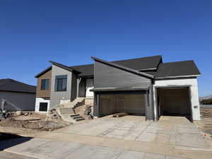 View of front of property with driveway and an attached garage