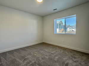 Carpeted spare room with baseboards