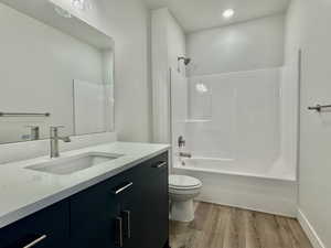 Bathroom featuring vanity, light wood finished floors, and shower / washtub combination