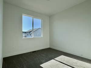 Empty room featuring baseboards and carpet