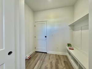Mudroom featuring light wood-style floors and baseboards