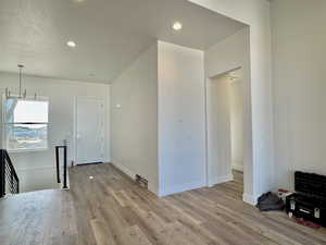 Unfurnished living room with light wood-style floors, a textured ceiling, and recessed lighting