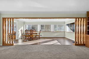 Carpeted dining room featuring crown molding
