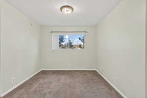 Empty room featuring carpet floors and baseboards
