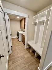 Mudroom with light wood style tile flooring, leading into the laundry room