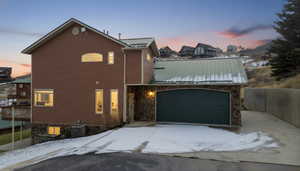 View of front of home with a metal roof, stone siding, and a standing seam roof