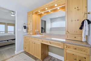 Full bathroom with healthy amount of natural light, vanity, and connected bathroom