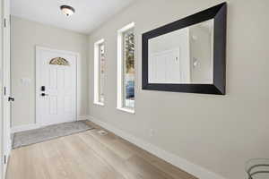 Entryway featuring baseboards and light wood finished floors