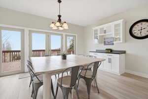 Dining area with light wood-style flooring and a chandelier