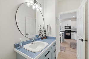 Bathroom featuring vanity, light wood finished floors, and a chandelier