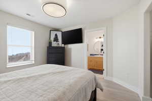 Bedroom featuring light wood-type flooring and connected bathroom