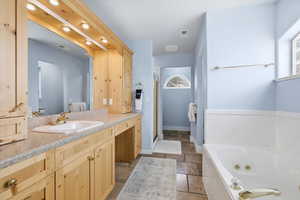Full bathroom with vanity, stone tile floors, a jetted tub, a shower stall, and recessed lighting