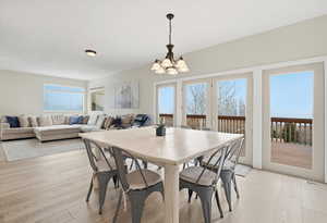 Dining room with light wood-type flooring and a chandelier