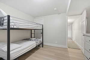 Bedroom with light wood-style flooring and wainscoting
