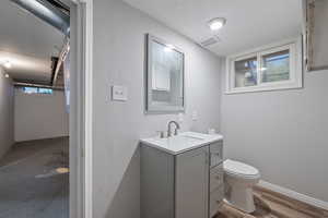 Half bath with vanity and dark wood-style flooring