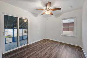 Unfurnished room featuring dark wood-type flooring and a ceiling fan