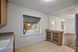 Unfurnished dining area with light wood-style flooring and a textured ceiling